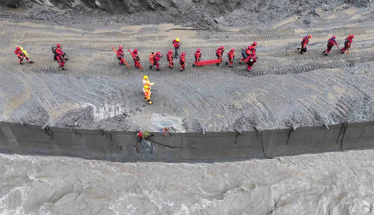 Petugas pemadam kebakaran dan penyelamat melakukan operasi pencarian dan penyelamatan pada ruas jalan menuju Pelabuhan Gyirong yang rusak akibat tanah longsor dua hari sebelumnya di Kabupaten Gyirong, wilayah Tibet di Tiongkok bagian barat, Sabtu, 29 Agustus 2026. (AFP/ CNS)