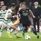 Luka Modric (kanan) diapit oleh dua pemain Celtic saat Real Madrid bertanding pada laga perdana Liga Champions 2022/2023, Rabu (7/9/2022) dini hari WIB. El Real menang 3-0. (AP Photo/Scott Heppell)