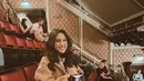 OOTD Yasmine Napper saat nonton musikal. Ia mengenakan setelan bermotif ditumpuk long coat wol berwarna cokelat, dipadu dengan sneakers putih dan mini bag hitam. [Foto: Instagram/yasminnapper]