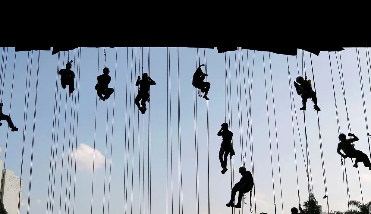 Pendaki saat mengatur posisinya dalam membuat bentuk cincin Olimpiade 2016 di sebuah jembatan di Sao Paulo, Brasil (31/7). Aksi ini dilakukan untuk menyambut dan memeriahkan Olimpiade 2016. (REUTERS/Paulo Whitaker) 