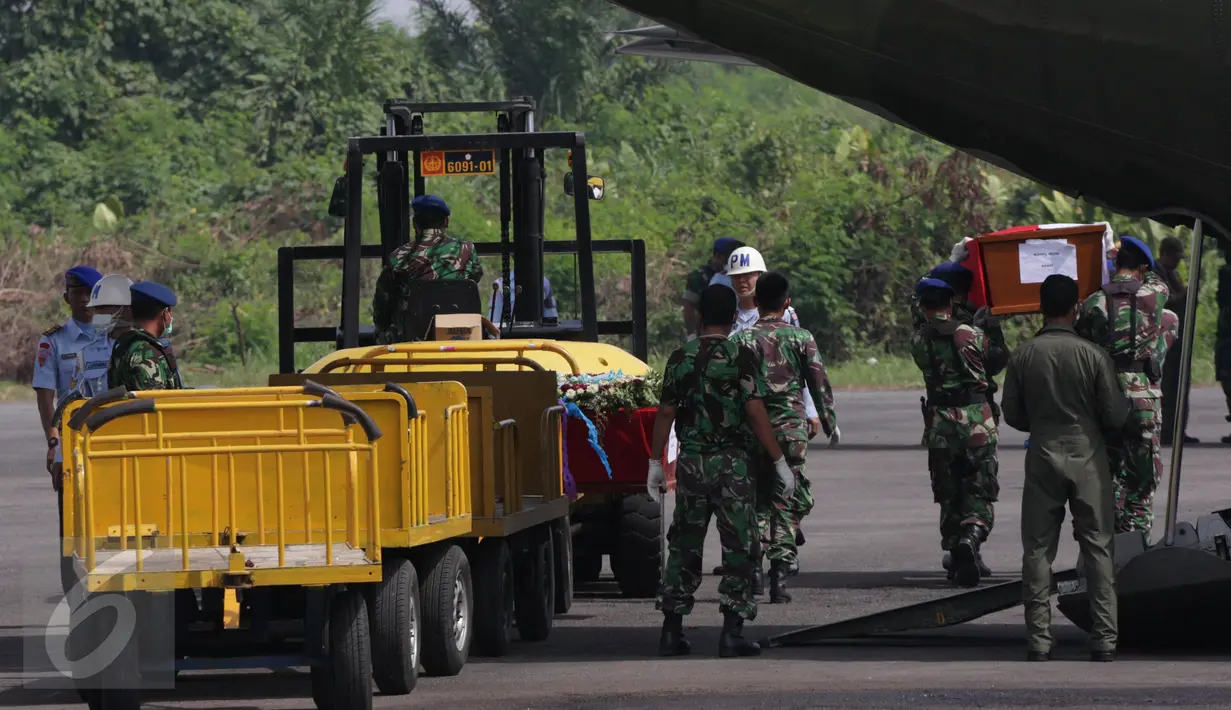 Petugas saat memindahkan peti jenazah dari pesawat Hercules bernomor ekor 1321 ke pesawat pengganti jenis CN 295, di Lanud Soewondo, Medan, Jumat (3/7). Pemindahan itu karena muncul percikan api di bagian kokpit Hercules C-130. (Liputan6.com/Johan Tallo)