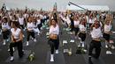 Para penggemar yoga melakukan yoga selama acara "Brew Yoga" saat matahari terbit di landasan pacu Bandara Suvarnabhumi di Bangkok, Thailand, Sabtu (27/4/2024). (MANAN VATSYAYANA / AFP)