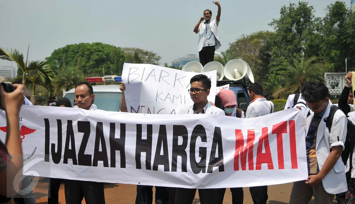 Puluhan dokter dari Pergerakan Dokter Muda Indonesia (PDMI) membentangkan spanduk di depan Istana Merdeka, Jakarta, Senin (7/9/2015). Mereka memprotes Kemenristek Dikti yang telah menahan ijazah fakultas kedokteran mereka. (Liputan6.com/Gempur M Surya)