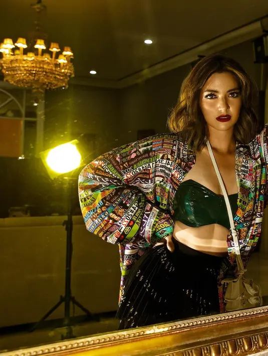 Masih dengan makeup bold namun memiliki look yang berbeda. Di mana makeup mata menjadi less dramatic dan dipadukan dengan red bold lips. (instagram/denymirrorcle)