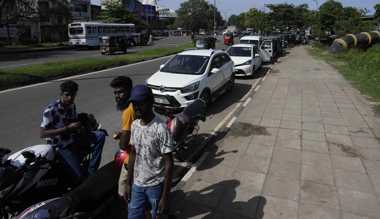Pengendara menunggu dalam antrean mengharapkan untuk membeli bahan bakar di Kolombo, Sri Lanka, Minggu (26/6/2022). Perdana Menteri Ranil Wickremesinghe mengungkapkan bahwa ekonomi Sri Lanka telah bangkrut setelah berbulan-bulan berjuang menghadapi kekurangan pasokan  makanan, bahan bakar dan listrik. (AP Photo/Eranga Jayawardena)