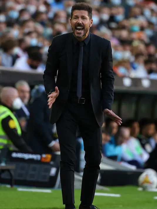 Pelatih Atletico Madrid, Diego Simeone berteriak menginstruksikan pemainnya saat bertanding melawan Valencia pada pertandingan lanjutan La Liga Spanyol di stadion Mestalla di Valencia (8/11/2021). Valencia bermain imbang atas Atletico Madrid 3-3. (AFP/Jose Jordan)