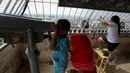 Dua orang bocah tampak menggunakan teropong untuk melihat Jakarta dari puncak Monas, Jakarta, Kamis (14/5/2015). Jumlah pengunjung mengalami peningkatan tinggi bertepatan libur kenaikan Isa Almasih. (Liputan6.com/Faizal Fanani)