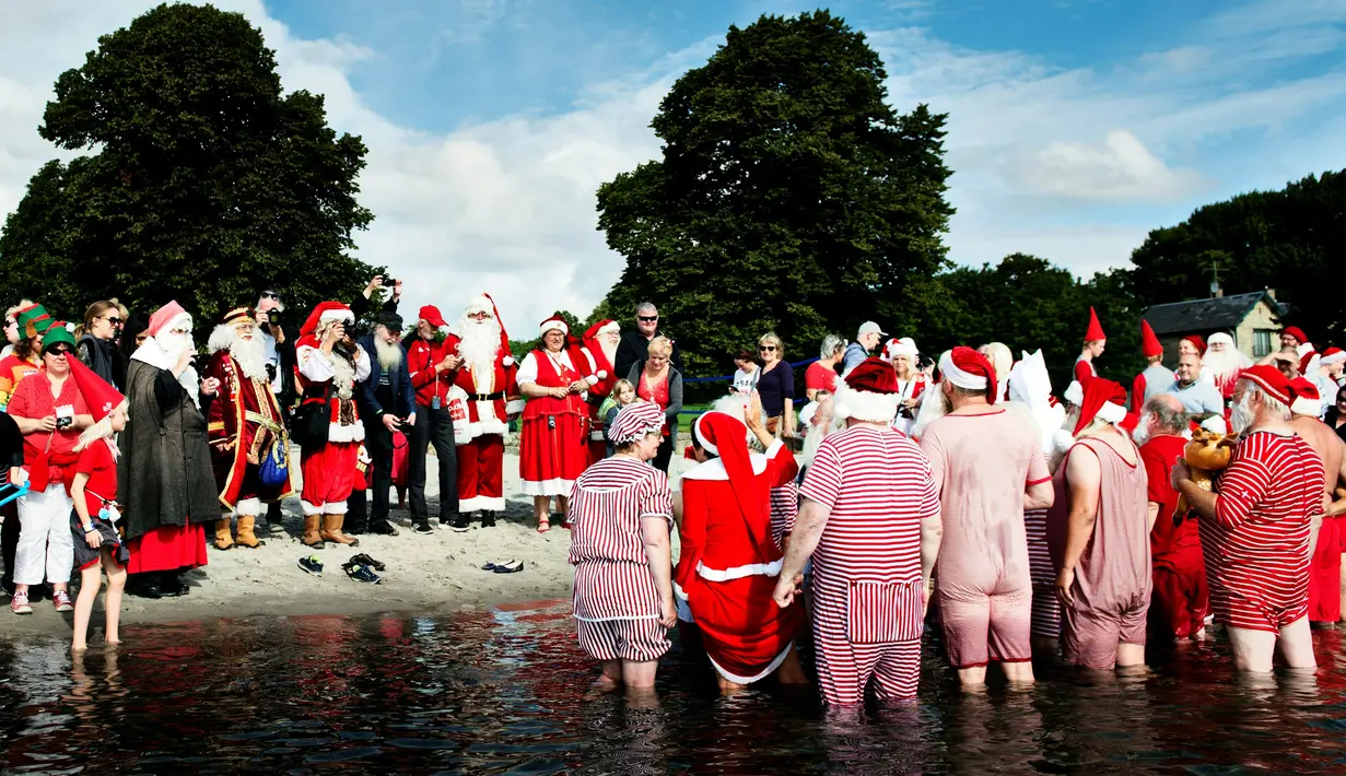 Sinterklas dari seluruh dunia berkumpul pada hari kedua Konvensi Musim Panas Sinterklas ke-59 di Kopenhagen, Denmark, 19 Juli 2016. Mereka memulai hari dengan berenang di pantai Bellevue. (Mathias Loevgreen Bojesen/Scanpix Denmark/AFP)