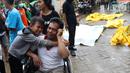 Seorang anak menangis memeluk ayahnya pasca terjadinya gelombang di Puskesmas Carita, Banten, Minggu (23/12). BNPB mencatat ratusan orang meninggal dunia dan ratusan luka-luka. (Liputan6.com/Angga Yuniar)