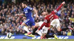 Gelandang Eden Hazard saat menggiring bola melewati pemain MU, Wayne Rooney