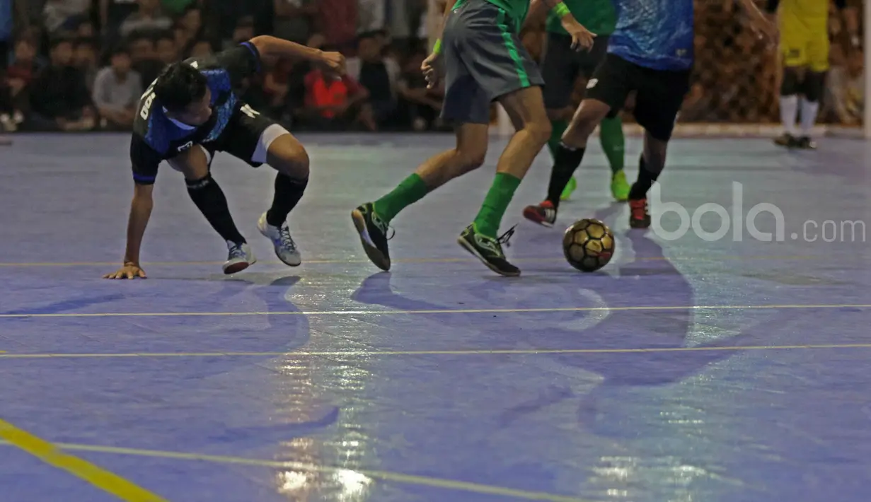 Pemain Timnas Futsal Indonesia, Reza Yamani (tengah) mencoba melewati para pemain BJL 2000 pada laga Uji Coba di Lapangan Futsal Tifosi Sport Center, Jakarta, (14/1/2017). Timnas menang 7-5. (Bola.com/Nicklas Hanoatubun)