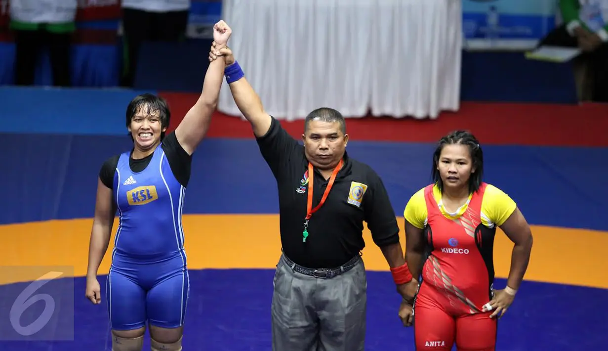 Pegulat putri Kalimantan Selatan Ridha W (biru) saat dinyatakan menang oleh wasit atas Anita (Kaltim) di final gaya bebas kelas 63 kg melawan Anita (Kaltim) pada PON XIX di Arena Saparua Sport Park, Bandung, Sabtu (24/9). (Liputan6.com/Helmi Fithriansyah)