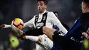 Gelandang Juventus, Joao Cancelo berebut bola dengan gelandang Inter Milan, Ivan Perisic selama pertandingan lanjutan Liga Serie A Italia di Allianz stadium, Turin (7/12). Juventus menang tipis atas Inter Milan 1-0. (AFP Photo/Marco Bertorello)