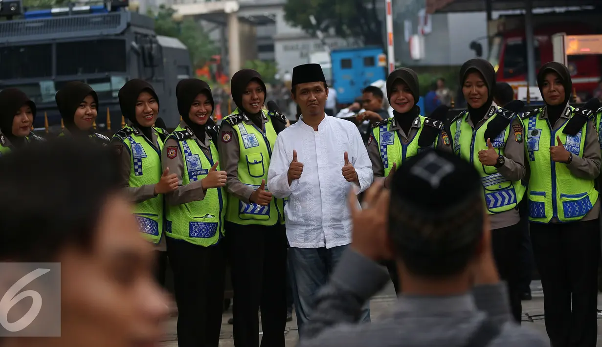 Massa Aksi 4 November 2016 melakukan foto bersama Polwan Cantik di depan Balai Kota, Jakarta, Jumat (4/11). Polwan cantik yang berjaga saat demo ini laris dan memukau para pendemo untuk berfoto bersama. (Liputan6.com/Johan Tallo)