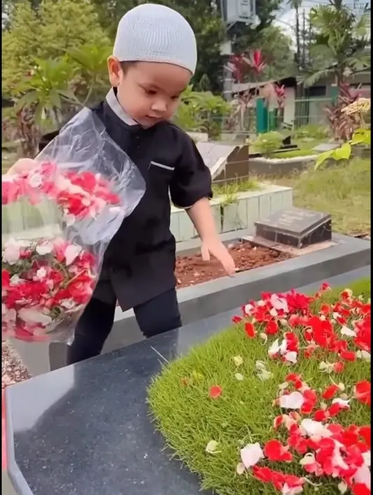 Dua tahun kepergian papa mamanya, Gala tampak nyekar. Bocah yang berusia tiga tahun itu mengenakan pakaian muslim hitam dan peci. [TikTok/dianaalstri22]