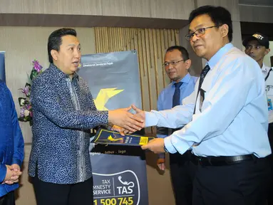 Presiden Direktur PT Adaro Energy Tbk, Garibaldi Thohir (kedua kiri) dan Pengusaha nasional Erick Thohir (kiri) menyerahkan laporan data aset kepada Kepala Kanwil DJP Wajib Pajak Besar, Jakarta, Rabu, (14/9). (Liputan6.com/Angga Yuniar)