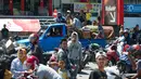 Sebuah mobil yang membawa peti mati dari kerabat mereka melintas saat warga menjarah toko serba ada setelah gempa dan tsunami di Palu, Sulteng, Minggu (30/9). Warga terpaksa mengambil karena membutuhkan makanan dan air bersih. (AFP PHOTO/BAY ISMOYO)