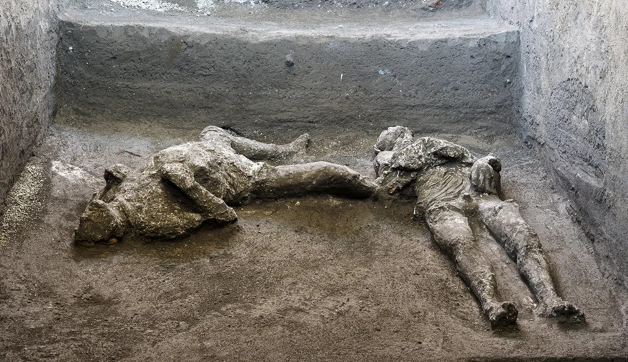 Dua jasad diyakini sebagai orang kaya dan budak prianya yang melarikan diri dari letusan gunung berapi Vesuvius hampir 2.000 tahun lalu, di sebuah vila, pinggiran kota Romawi kuno Pompeii. Penemuan diumumkan otoritas arkeologi Italia pada Sabtu (21/11/2020). (Parco Archeologico di Pompei via AP)