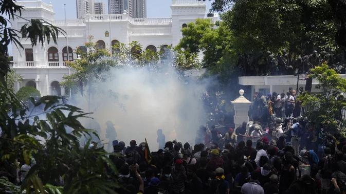 Polisi menggunakan gas air mata saat pengunjuk rasa Sri Lanka menyerbu kantor perdana menteri Ranil Wickremesinghe di Kolombo, Sri Lanka, Rabu, 13 Juli 2022. (Rafiq Maqbool/AP)