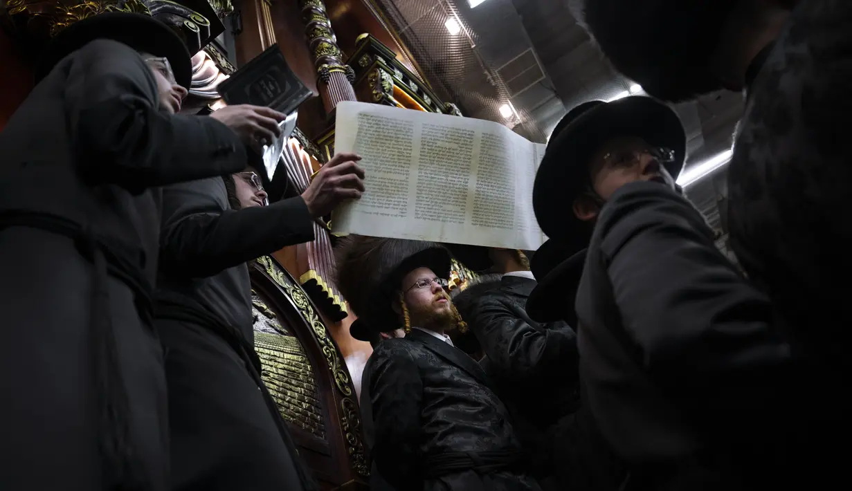 Pria ultra-Ortodoks Yahudi membaca Kitab Ester, yang menceritakan kisah festival Yahudi Purim, di sebuah sinagoga di Bnei Brak, Israel, Senin (6/3/2023).Hari raya Purim Yahudi memperingati keselamatan orang Yahudi dari genosida di Persia kuno, sebagaimana diceritakan dalam Kitab Ester. (AP Photo/Oded Balilty)