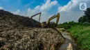 Alat berat mengangkat sampah untuk mengurangi volume longsor tempat pembuangan akhir (TPA) Cipayung yang menimbun Kali Pesanggrahan di Depok, Jawa Barat, Selasa (30/4/2024). (merdeka.com/Arie Basuki)