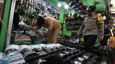 Petugas gabungan dari Satpol PP, kepolisian, dan Kelurahan Kota Bambu Selatan melakukan razia peredaran obat tramadol di kawasan KS Tubun, Tanah Abang, Jakarta Pusat, Selasa (13/10/2026). Razia ini dilakukan untuk mengawasi peredaran obat yang berpotensi disalahgunakan. (KLY/Budy Santoso)