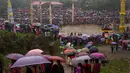 Ratusan warga dari suku India Pnar membawa payung saat menonton Festival Behdienkhlam di desa Tuber, India (24/7). Festival Behdienkhlam adalah tradisi setempat di kawasan Meghalaya yang digelar setiap tahun. (AP Photo/Anupam Nath)