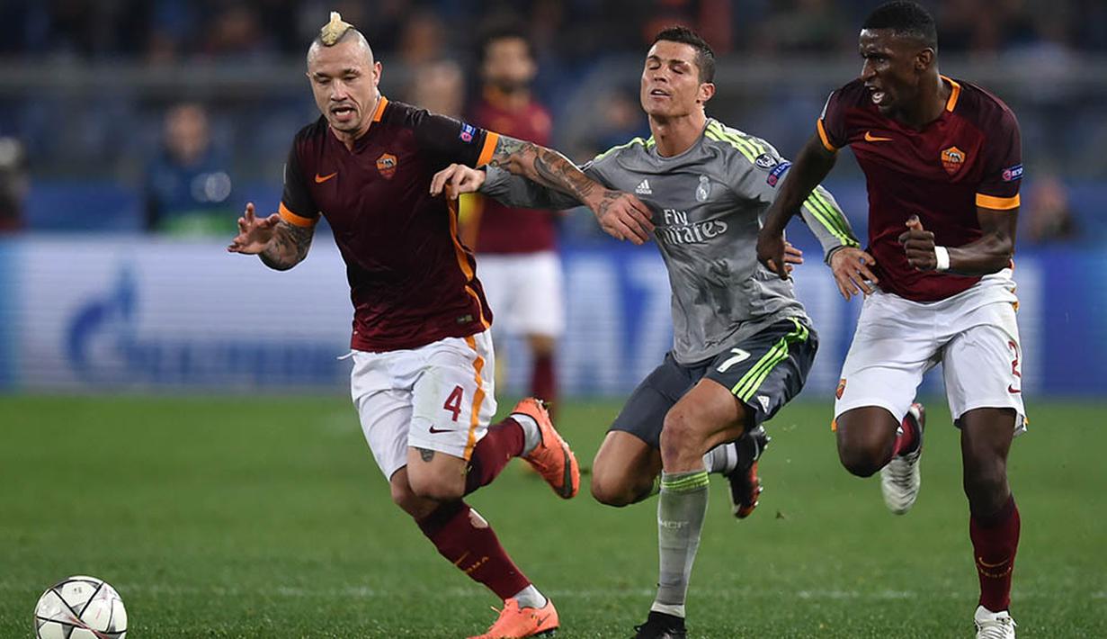 Pergerakan dari bintang Real Madrid, Cristiano Ronaldo, ditahan dua pemain Roma. Gol ke gawang Roma itu kian mengokohkan dirinya sebagai pencetak gol terbanyak Liga Champions sepanjang masa dengan torehan 89 gol. (AFP/Alberto Pizzoli)
