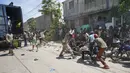 Polisi menghadapi warga yang untuk sementara menyalip sebuah truk yang penuh dengan pasokan bantuan, di Les Cayes, Haiti, Jumat (20/8/2021).  Bantuan swasta dan kiriman dari pemerintah AS dan lainnya tiba di semenanjung barat daya negara itu. dilanda. (AP Photo/Fernando Llano)