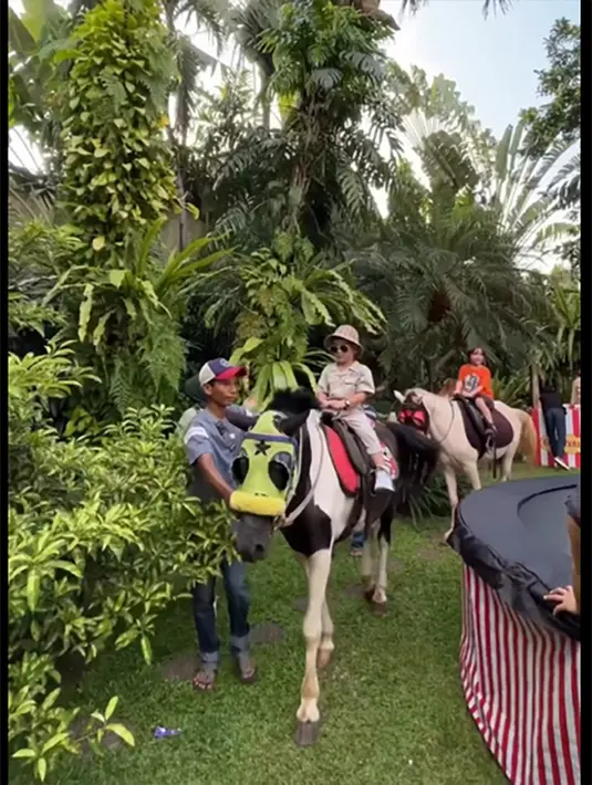 Halaman di kediaman Nia dan Ardi disulap menjadi taman bermain. Selain ada  hiburan musik live, juga ada banyak sekali permainan yang disediakan. [Instagram/tya_ariestya]