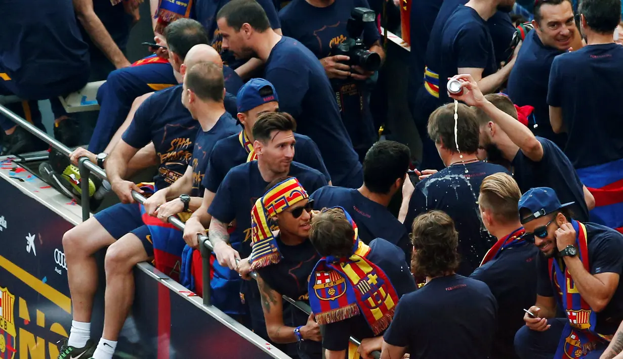 Lionel Messi (tengah) dan sejumlah punggawa Barcelona lainnya berpesta juara bus terbuka di sepanjang jalan Barcelona , Spanyol , 15 Mei 2016. Barcelona sukse merengkuh juara Liga Spanyol yang ke-24. (REUTERS / Albert Gea)