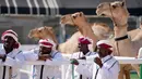 Para penjaga unta menunggu hasil Kontes Kecantikan Unta di Qatar Camel Mzayen Club, Ash-Shahaniyah, Qatar, 2 Desember 2022. Selama acara berlangsung, unta yang terus mengunyah diarak di hadapan penonton yang duduk di dalam ruangan dan menikmati kopi dan manisan. (AP Photo/Natacha Pisarenko)