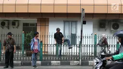 Penumpang menaiki pagar pembatas untuk keluar dari Stasiun Cikini di Jakarta, Jumat (22/3). Jauhnya akses pintu masuk dan keluar stasiun menyebabkan sebagian orang mempersingkat waktu dengan melompat pagar pembatas. (Liputan6.com/Immanuel Antonius)