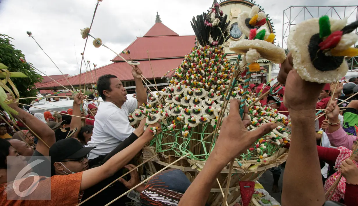 Warga berebut mengambil sesuatu di gunungan saat Grebeg Idul Adha, Yogyakarta, Selasa (13/9). Acara tahunan ini menjadi salah satu daya tarik kota Yogyakarta. (Liputan6.com/Boy Harjanto)