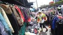 Pembeli melihat barang dagangan di kawasan Pasar Senen, Jakarta, Senin (23/1). Pascakebakaran beberapa hari lalu, para pedagang terpaksa berjualan di luar gedung, meskipun menutup jalan dan mengganggu arus lalu lintas. (Liputan6.com/Immanuel Antonius)