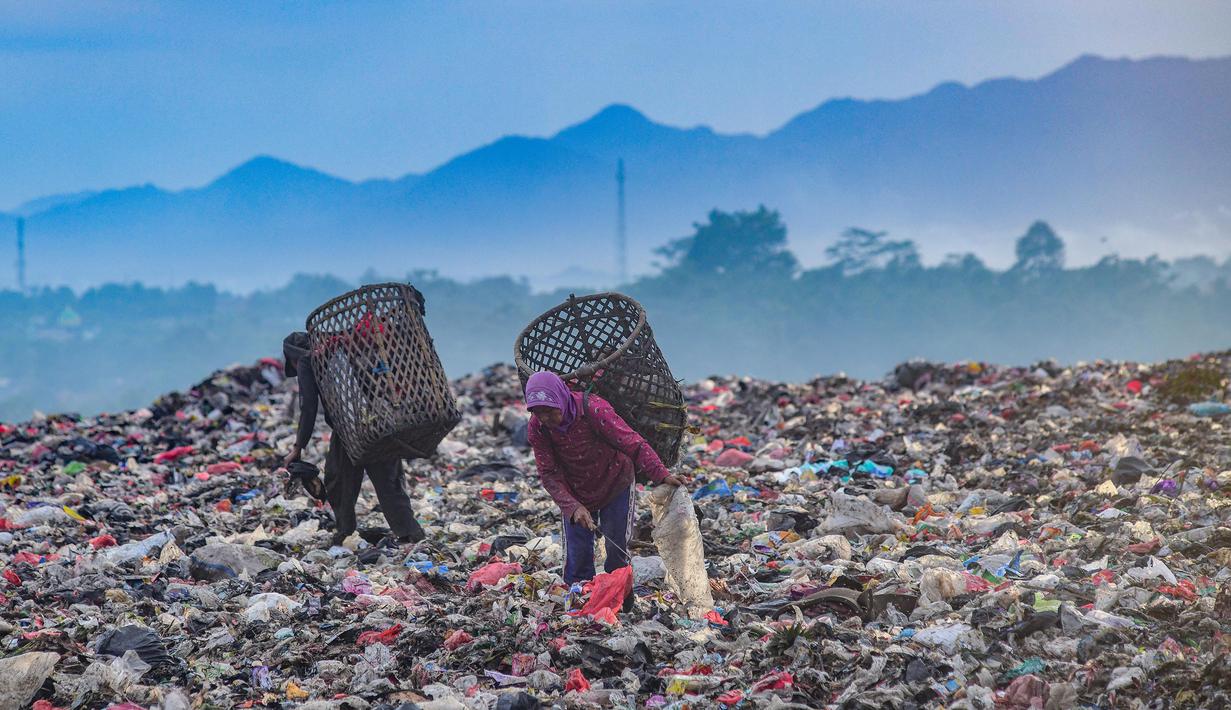 Warga yang berprofesi sebagai pemulung mengumpulkan sampah plastik dengan latar belakang Gunung Gede-Pangrango di Tempat Pembuangan Akhir Galuga, Bogor, Kamis (6/11/2025). Penutupan tumpukan sampah atau capping dilakukan sambil menunggu proses penyelesaian TPA open dumping yang banyak ditemukan di berbagai wilayah. (merdeka.com/Arie Basuki)