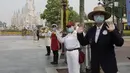 Pegawai mengenakan masker saat menyambut wisatawan di taman hiburan Disneyland, Shanghai, China, Senin (11/5/2020). Disneyland Shanghai kembali dibuka setelah tiga bulan ditutup akibat pandemi virus corona COVID-19. (AP Photo/Chen Si)