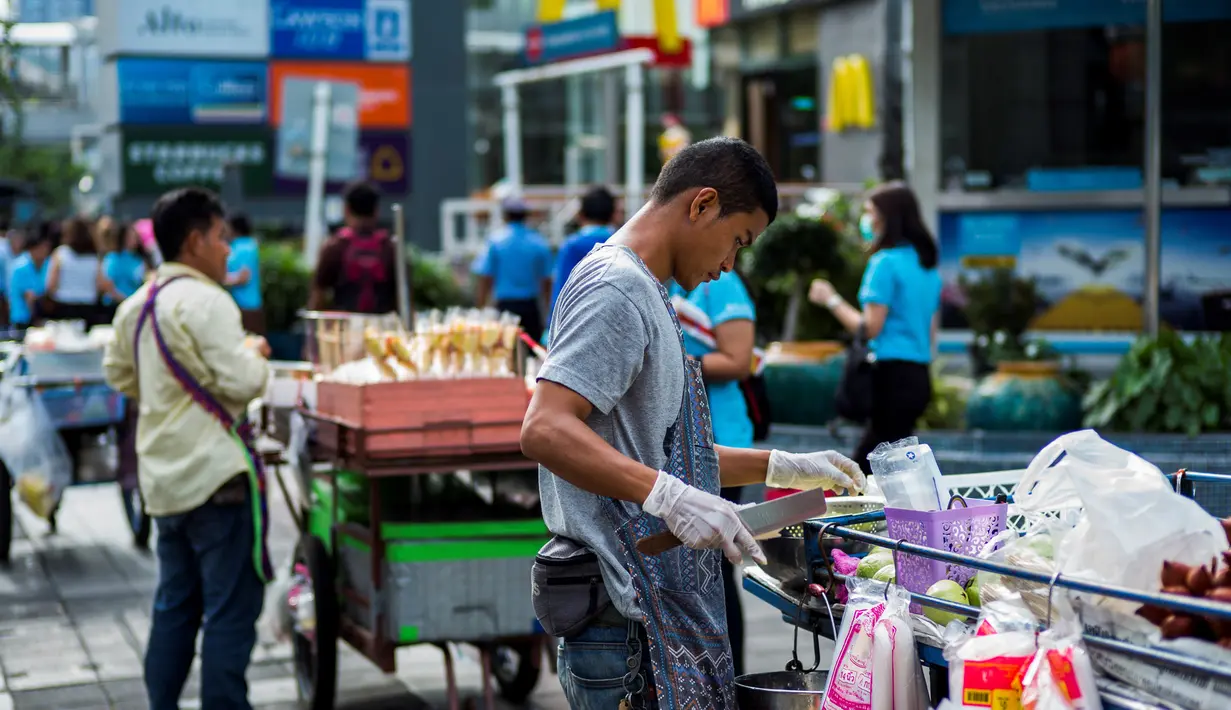 Seorang pedagang menyiapkan buah di jalan di Bangkok, Thailand (20/9). Menurut Narumol Nirathron dari Universitas Thammasat dalam laporan International Labour Organization, PKL makanan di Bangkok sudah ada sejak 200-an tahun lalu. (AFP Photo/Jewel Samad)