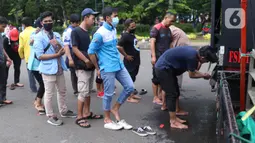 Sejumlah buruh mengambil air wudhu untuk menunaikan salat zuhur di sela aksi Hari Buruh Internasional atau May Day di Jakarta, Sabtu (1/5/2021). Sejumlah massa yang tergabung dalam serikat pekerja menggelar unjuk rasa di Hari Buruh ini. (Liputan6.com/Angga Yuniar)