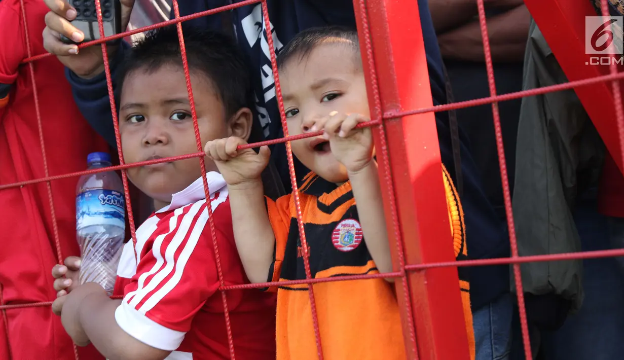 Suporter cilik tim Macan Kemayoran menyaksikan latihan perdana Persija pasca menjuarai Liga 1 musim 2018 di Lapangan Wisma Aldiron, Jakarta, Senin (7/1). 30 pemain ikut dalam latihan perdana yang digelar terbuka. (Liputan6.com/Helmi Fithriansyah)