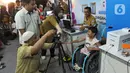 Petugas Disdukcapil Kota Tangerang Selatan melakukan pemotretan kartu identitas anak (KIA) untuk anak penderita Spina Bifida di  Lapangan Skadron 21 Sena Penerbad, Tangerang Selatan, Banten (25/11/2019). Sekitar 500 anak melakukan pembuatan KIA secara gratis. (merdeka.com/Arie Basuki)