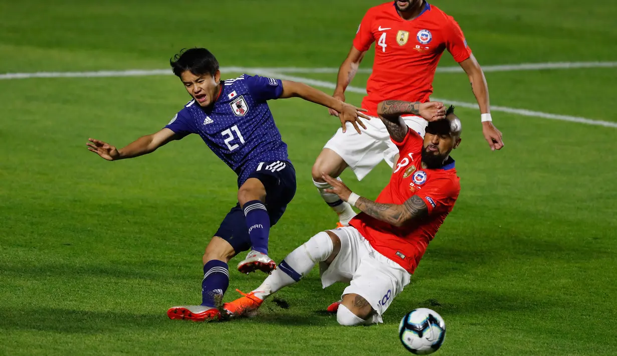 Gelandang Jepang, Takefusa Kubo saat dilanggar gelandang Chile, Arturo Vidal selama pertandingan grup C Copa America 2019 di Stadion Morumbi, Sao Paulo, Brasil (17/6/2019). Dalam pertandingan ini Jepang kalah telak atas Chile 4-0. (AFP Photo/Nelson Almeida)