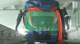 Pekerja membuka selubung skytrain yang baru dipasang di Terminal 3 Bandara Soekarno Hatta, Tangerang, Selasa (30/5). Kereta tanpa awak ini rencananya akan diuji coba mengangkut penumpang antara terminal 2 dan terminal 3. (Liputan6.com/Helmi Afandi)