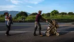 Seorang imigran Honduras mendorong kereta bayi dalam perjalanannya menuju Amerika Serikat di negara bagian Oaxaca, Meksiko, 29 Oktober 2018. Kereta dorong bayi telah menjadi barang mewah bagi para imigran dalam perjalanan mereka. (Guillermo Arias/AFP)