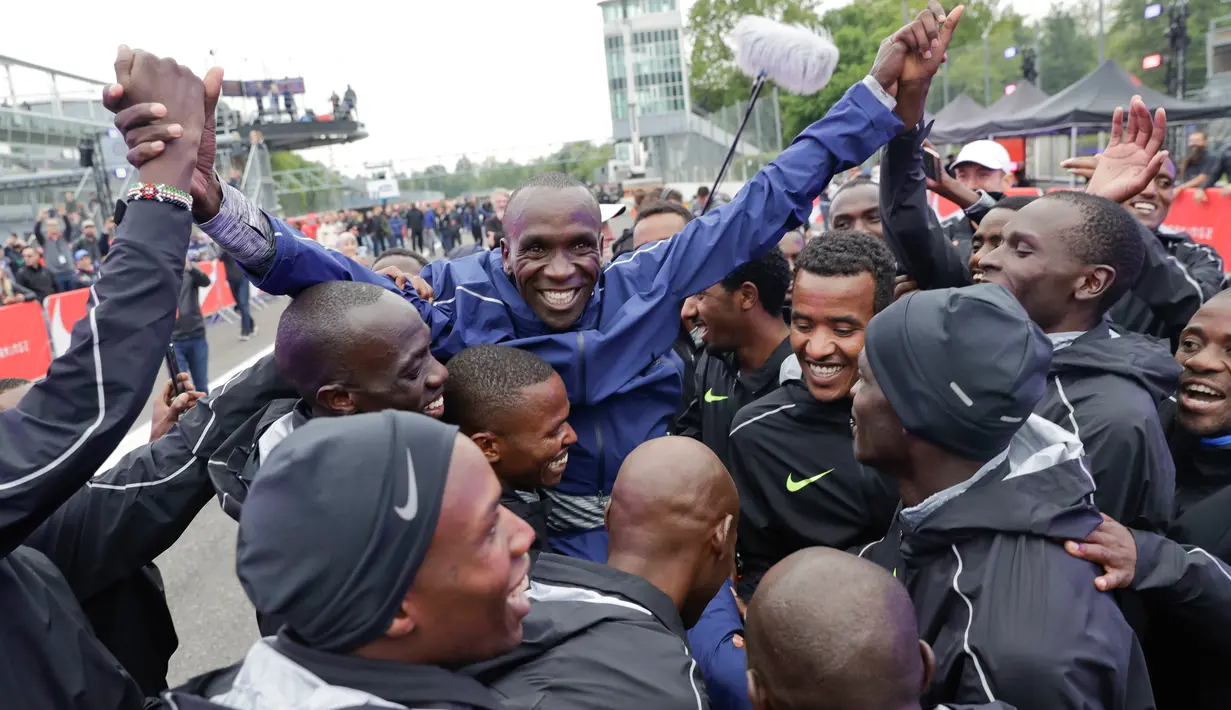 Pelari asal Kenya, Eliud Kipchoge (tengah) merayakan keberhasilannya dalam lari maraton di bawah 2 jam pada event Breaking2 di Sirkuit Monza, Italia, Sabtu (6/5). Eliud Kipchoge melahap 42.195 km dalam waktu 2 jam 0 menit 25 detik. (AP Photo/Luca Bruno)