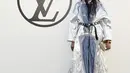 Naomi Campbell tampil futuristik dengan oversized coat berwarna silver biru yang dipadukan dengan celana panjang dan heels. (Louis Vuitton)