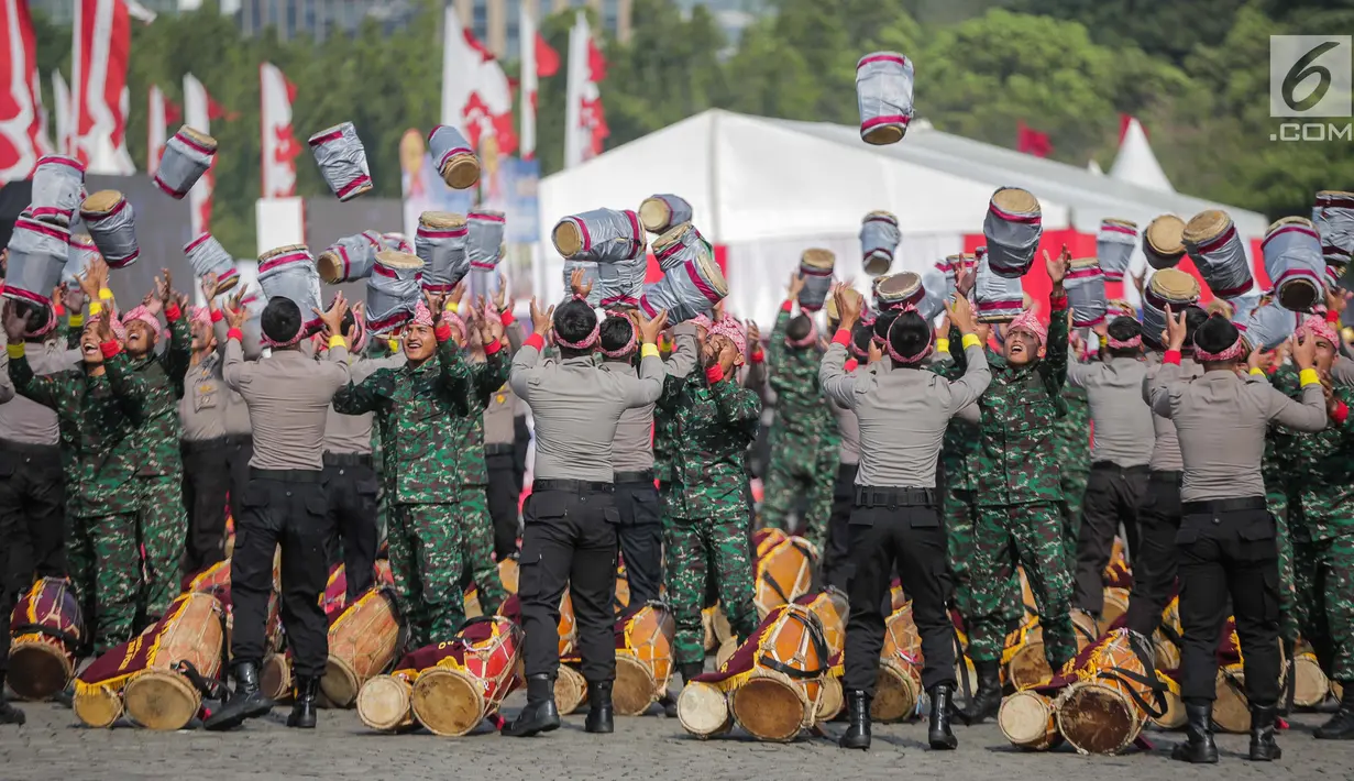 Prajurit TNI dan Polri berkolaborasi memainkan rampak gendang dalam HUT ke-73 Bhayangkara di Monas, Jakarta, Rabu (10/7/2019). HUT Bhayangkara ke-73 ini bertemakan ‘Dengan semangat Promoter, pengabdian Polri, untuk masyarakat, bangsa, dan negara. (Liputan6.com/Faizal Fanani)