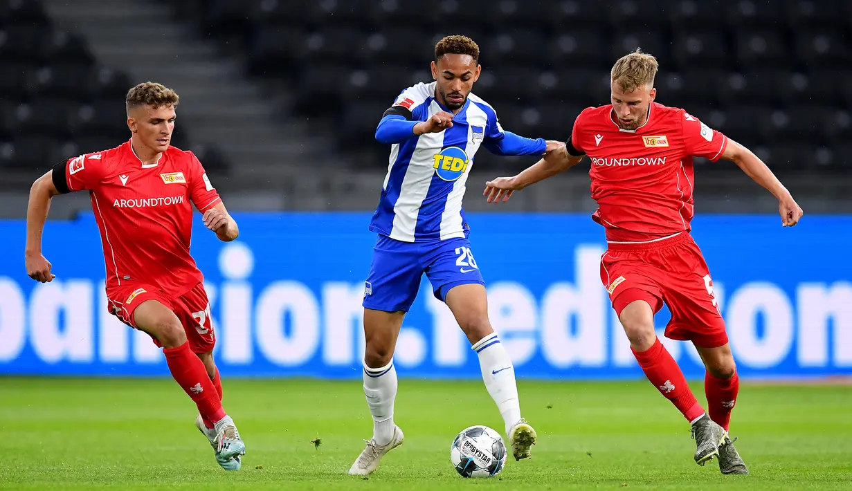 Penyerang Hertha Berlin, Dodi Lukebakio, berebut bola dengan pemain Union Berlin pada laga lanjutan Bundesliga di Stadion Olimpiade, Berlin, Sabtu (23/5/2020) dini hari WIB. Hertha Berlin menang 4-0 atas Union Berlin. (AFP/Stuart Franklin/Pool)