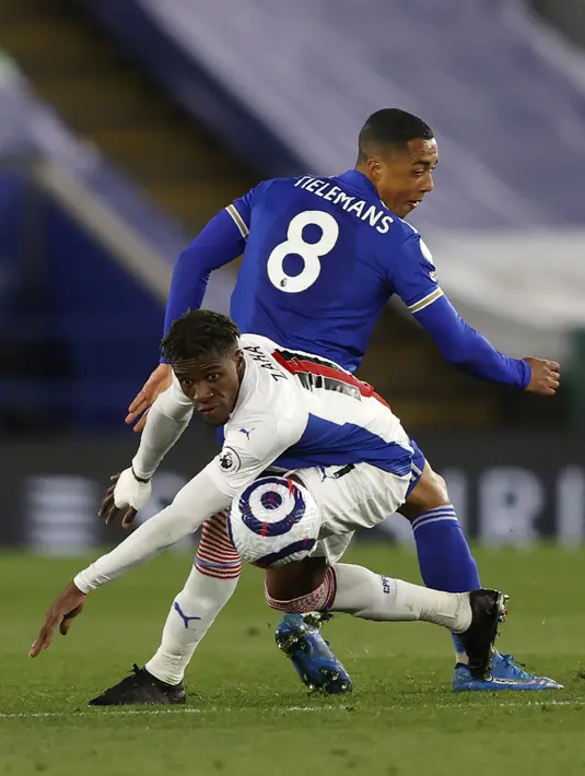 Penyerang Crystal Palace, Wilfried Zaha bersaing dengan gelandang Leicester City, Youri Tielemans dalam lanjutan Premier League digelar di King Power Stadium, Selasa (27/4/2021) dini hari WIB. Leicester City memetik kemenangan penting 2-1 di kandang atas Crystal Palace. (Adrian Dennis/Pool via AP)