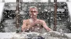 Seorang umat Kristen Ortodoks Rusia berendam dalam air es saat perayaan tradisional Epiphany di St. Petersburg, Rusia, Jumat (19/1/2024). (AP Photo/Dmitri Lovetsky)